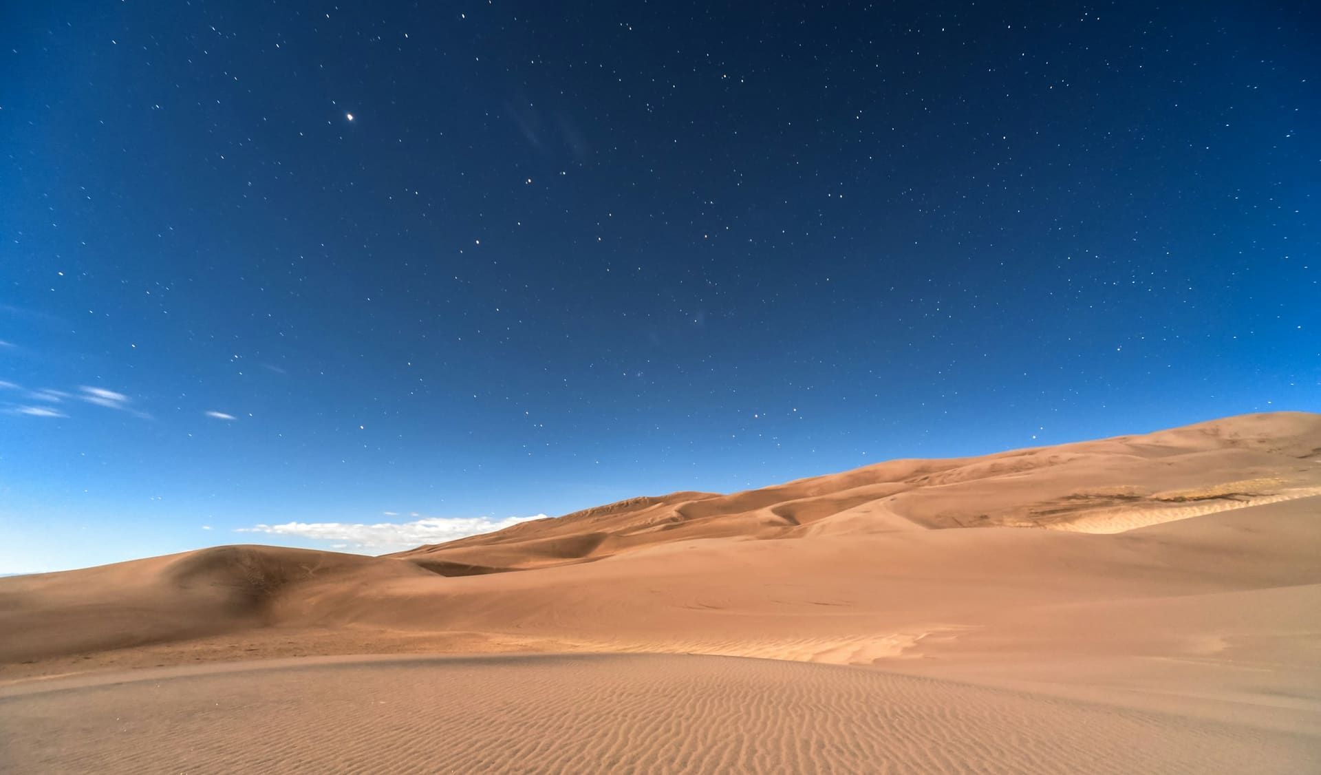 Private Toyota Land Cruiser at the edge of the red Lahbab dunes at golden hour