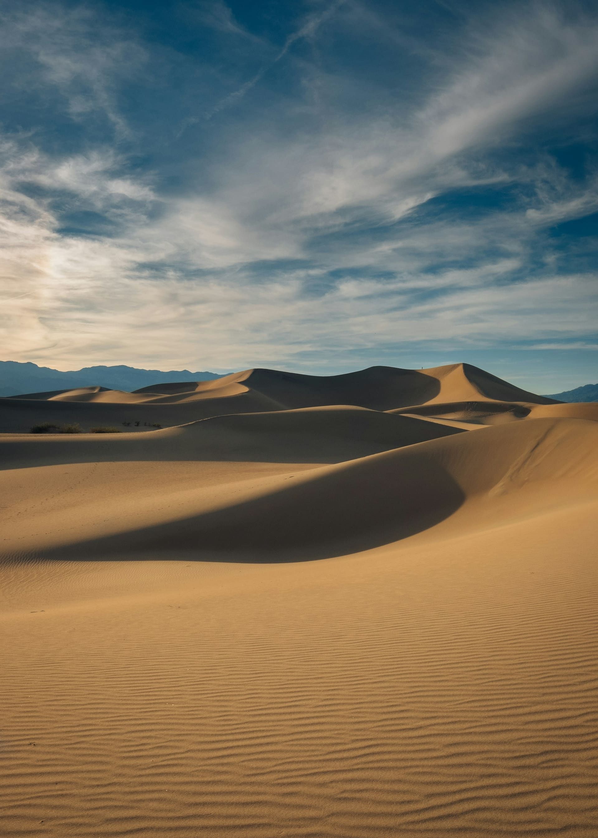 Golden desert dunes glowing under a warm evening sky