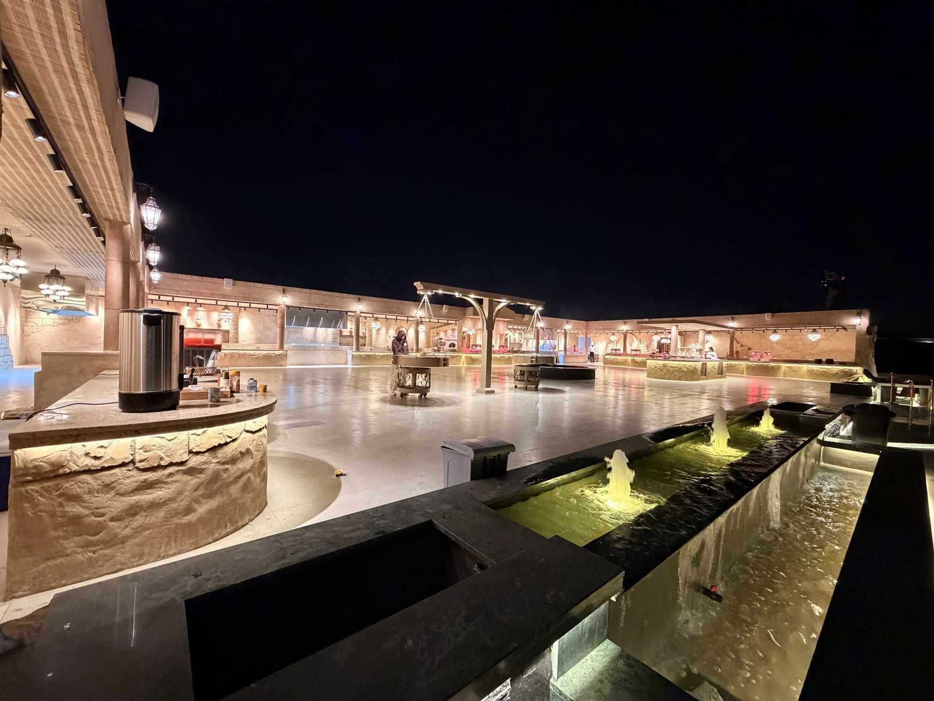 Lantern-lit VIP desert camp courtyard with fountains at night near Dubai