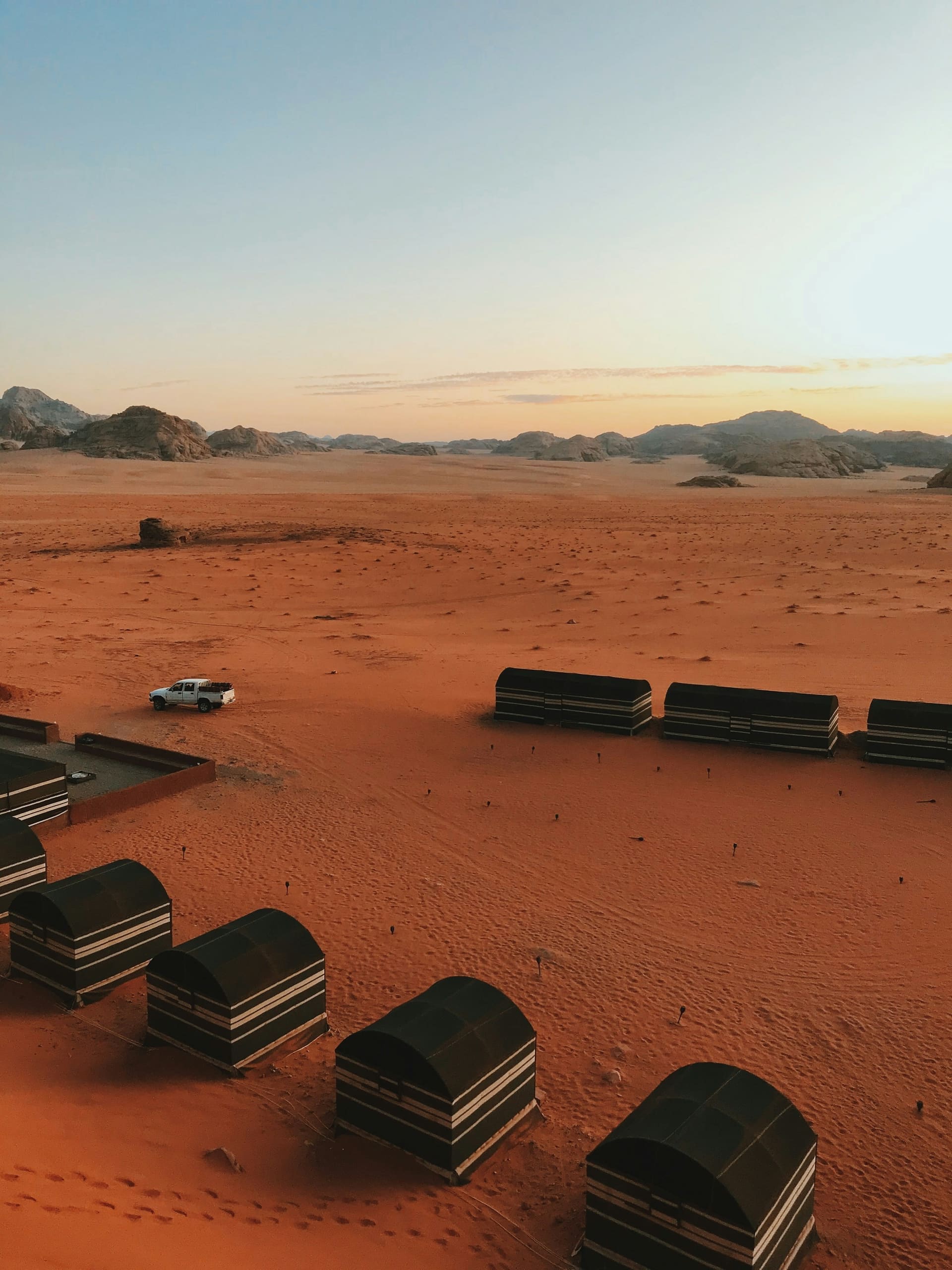 A private candle-lit majlis dinner table for two at a Dubai Bedouin camp at dusk