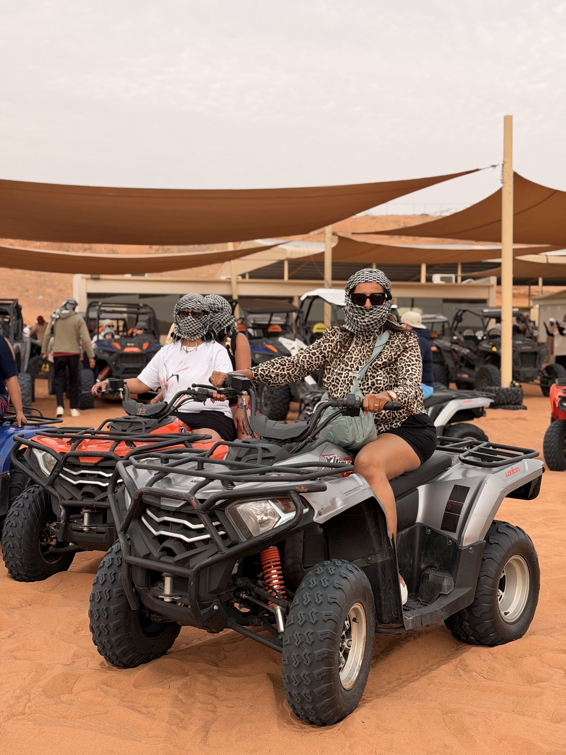 Two riders on quad bikes at the desert camp staging area