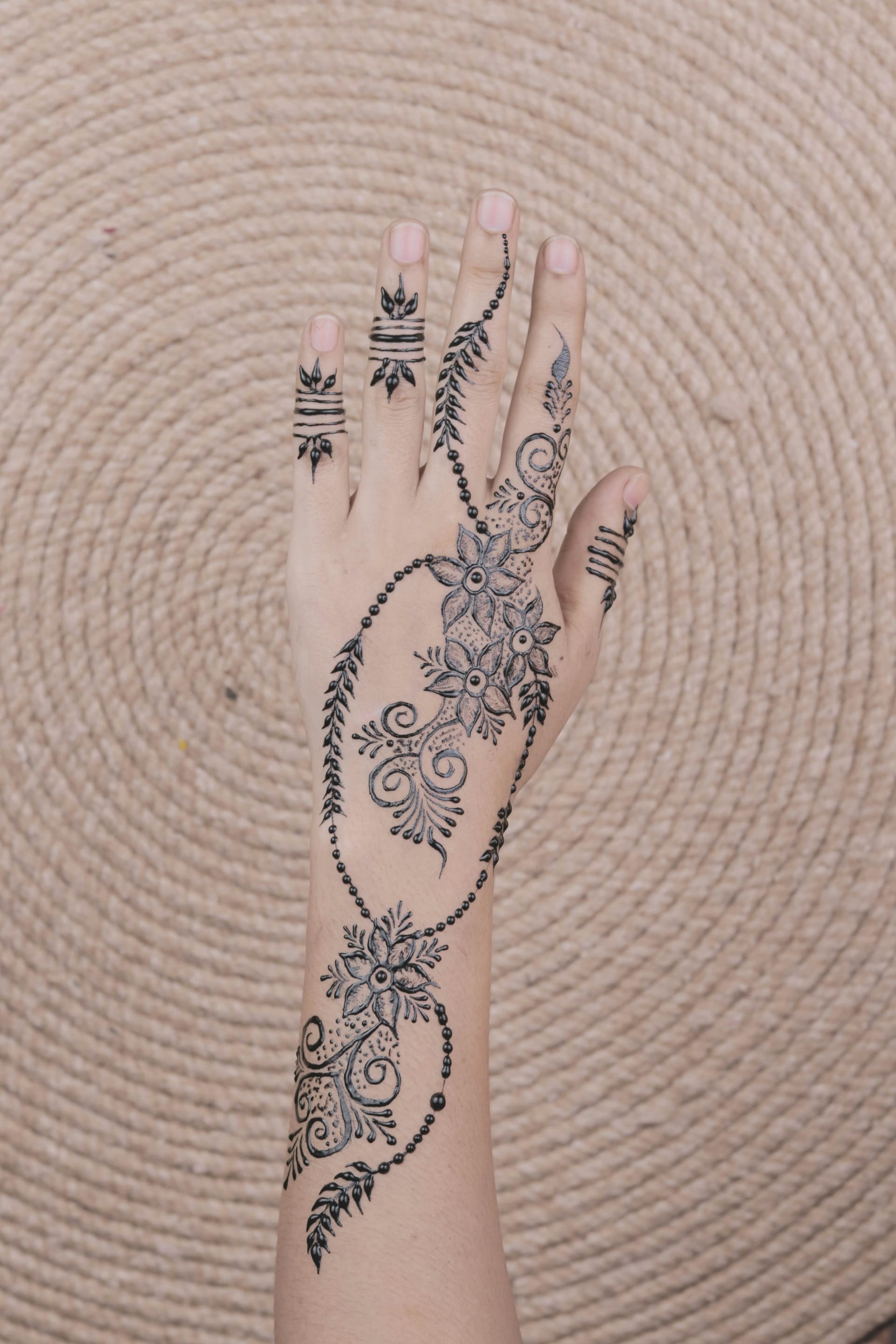 A child receiving floral henna on her hand at the desert camp