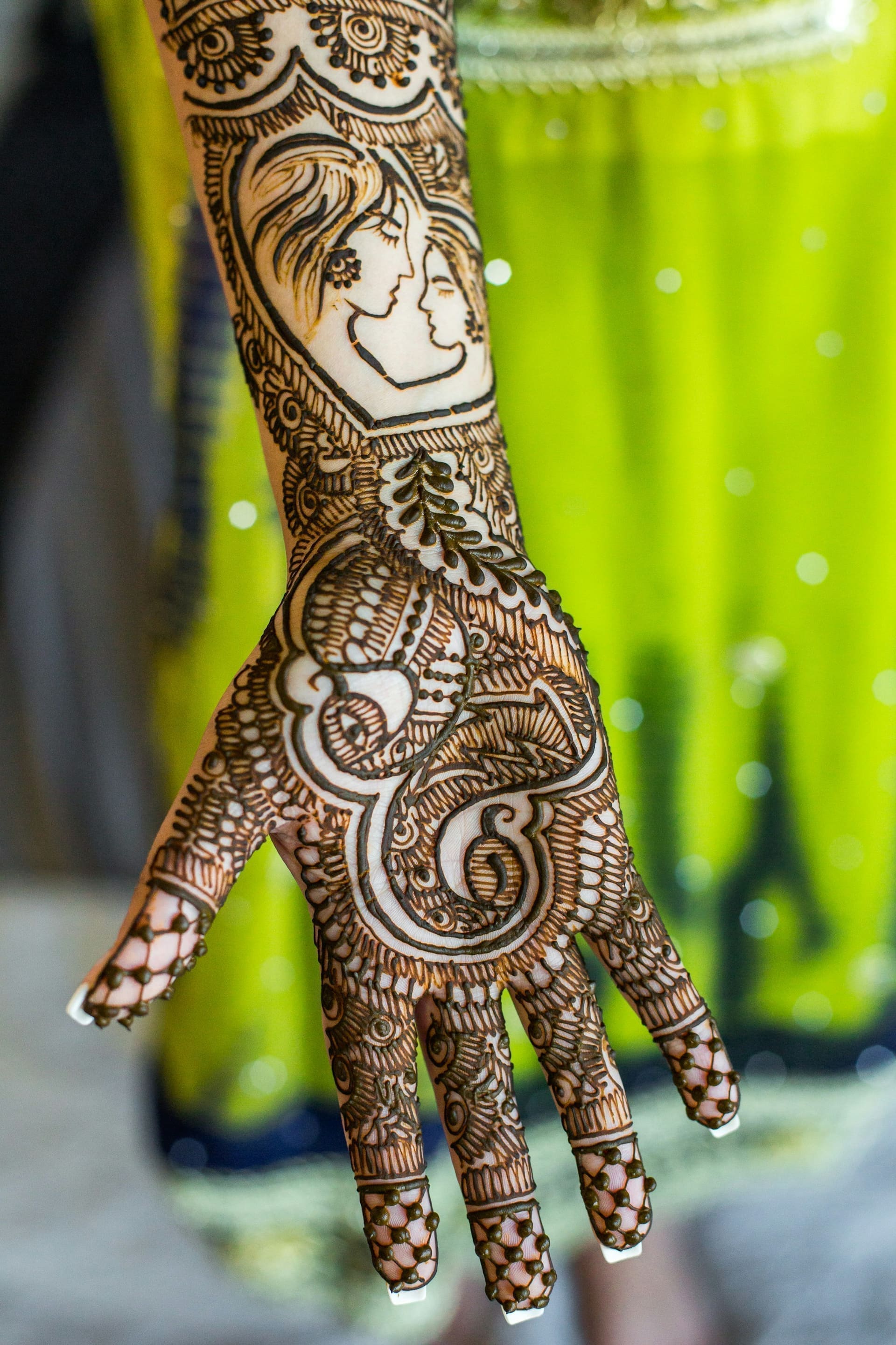 Henna artist applying a geometric floral pattern to a guest hand at the Bedouin camp