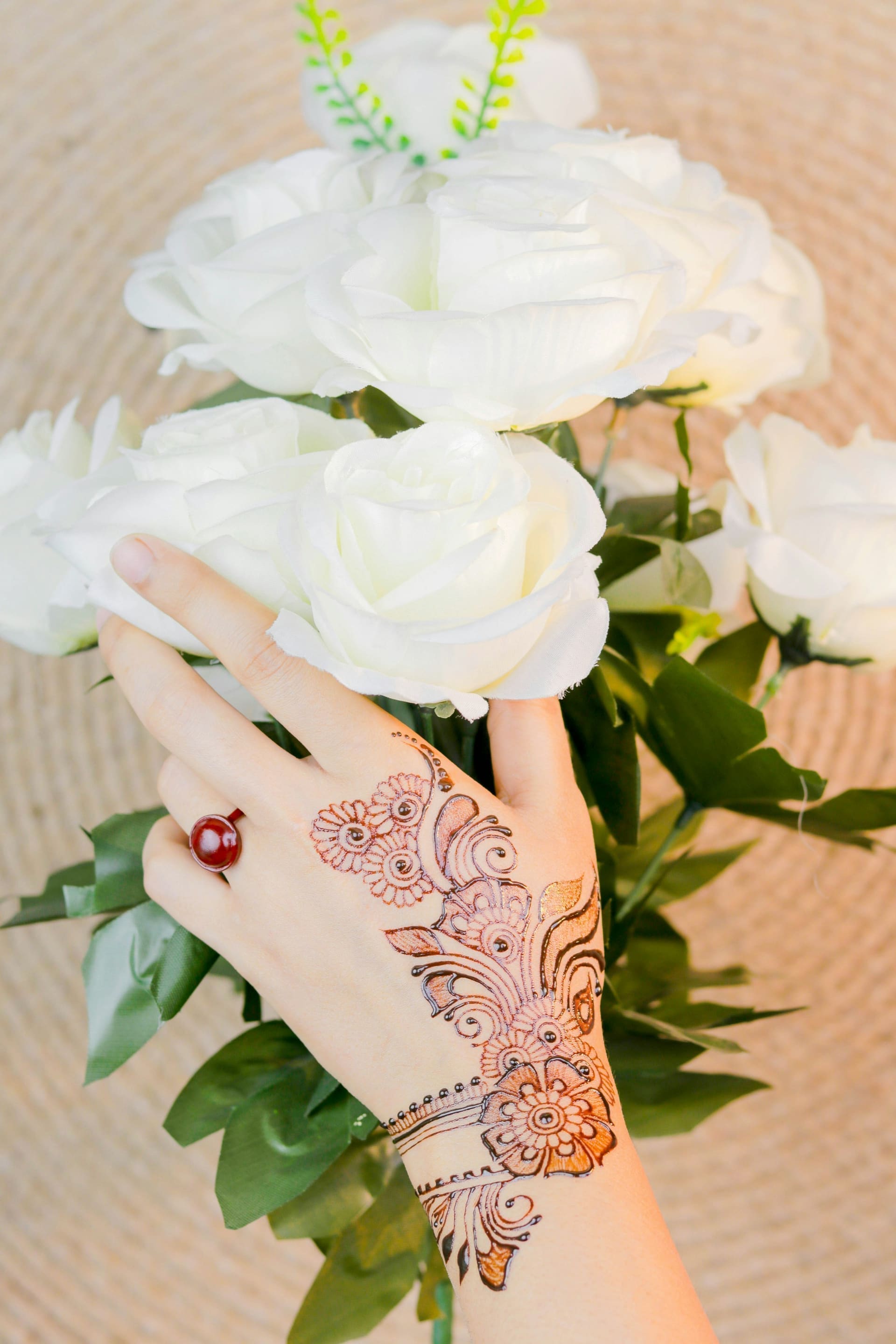 Henna-decorated hand with white roses at a luxury desert dinner