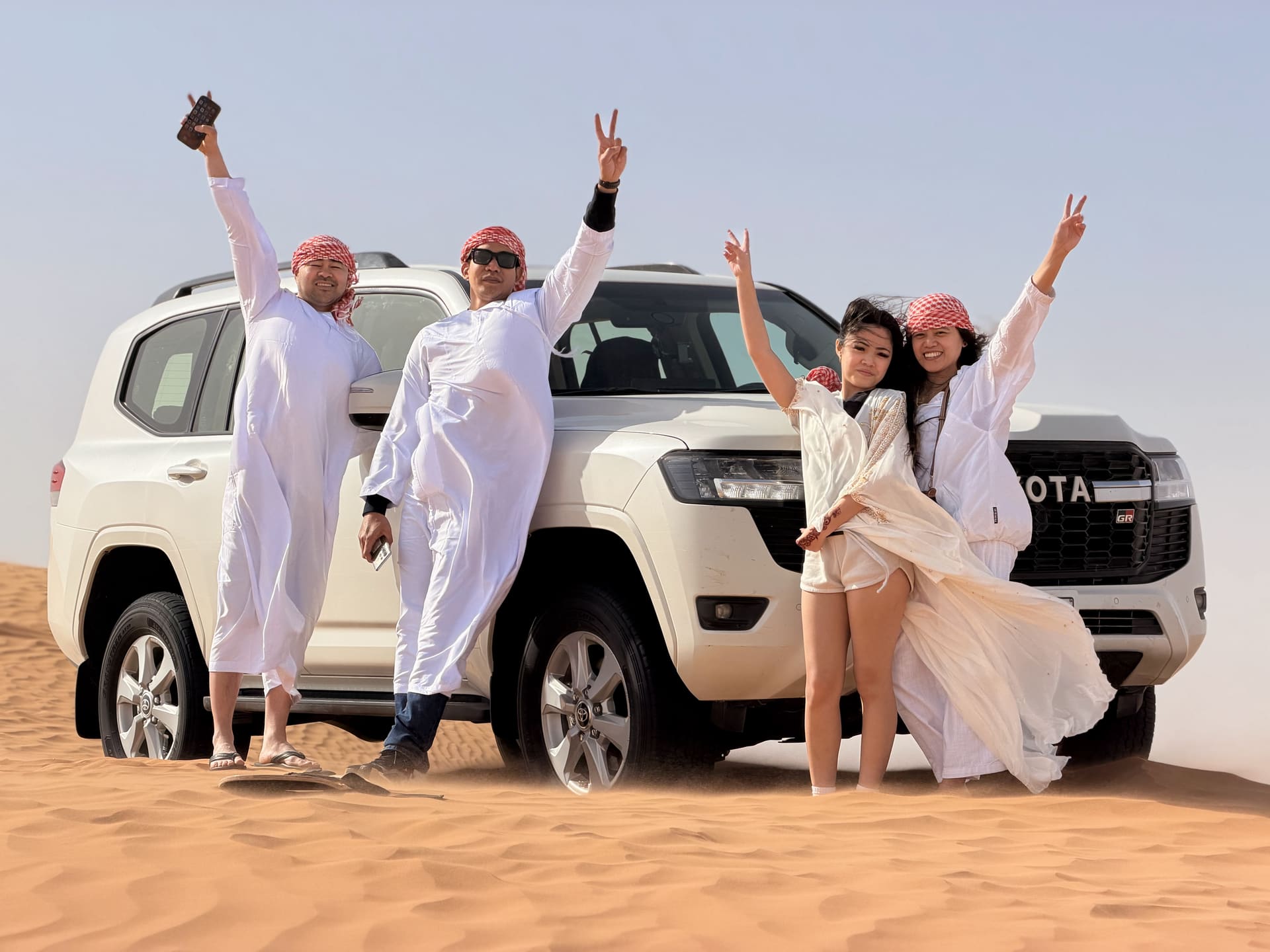 Guests with a private white Toyota Land Cruiser on the dunes